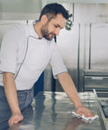 Chef cleaning kitchen surface with Bleach Disinfecting Wipes For Hospital Grade Surface Cleaning In Bathrooms And Equipment