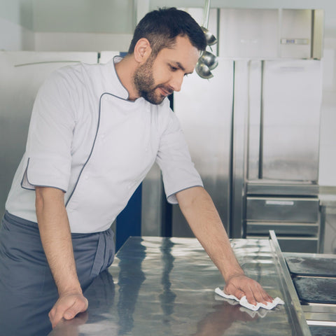 Chef cleaning kitchen surface with Bleach Disinfecting Wipes For Hospital Grade Surface Cleaning In Bathrooms And Equipment