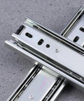 Heavy Duty Steel Ball Bearing Drawer Slides Featuring Slick Silent Telescopic Cabinet Runners on a gray surface.