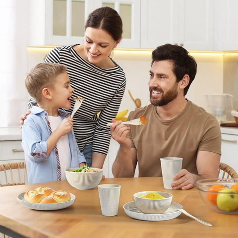 Family enjoying meal with 36 Piece Reusable Wheat Straw Dinnerware Set For Six With Plates, Bowls, Cups, And Utensils, Unbreakable