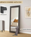 36 Inch Wide By 84 Inch Tall Mirror Barn Door Built Tough With 6.6 Foot Sliding Hardware Kit Included One Lite Full Length Glass Solid Wood Waterproof PVC Surface Scratch Resistant No Assembly Required Black leaning against a living room wall.