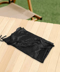 Trampoline Shade Net Weather Resistant Cover Tent folded on a wooden table, highlighting compact design; black fabric