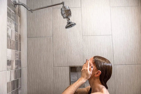 Person using High Output Shower Filter Cartridge for sensitive skin and dry scalp, softening hard water, improving hair and skin health
