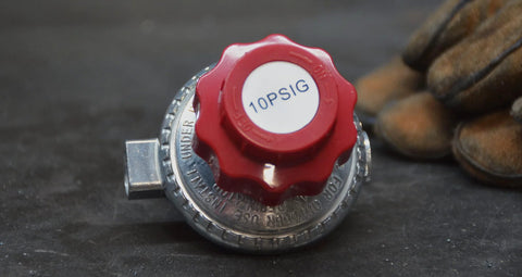 Propane regulator with red adjustment knob, Amazon brand, 0–10 psi adjustable (close-up view)