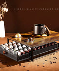 Wood And Iron Coffee Pod Holder Organizer For Drawer showing capsules and a mug on top, made of wood and reinforced alloy steel.