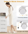 Five Drawer Rolling Storage Cart On Wheels White Plastic Organizer For Home Office And Living Room Mobile Cabinet With Three Large And Two Small Drawers Durable Vertical Storage Tower 16x13x31, woman standing next to cart, image showing wheels with brakes.