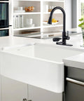 COXOVAY Pull Down Kitchen Faucet with Glass Rinser Single Handle Kitchen Sink Faucet with Pull Out Sprayer, Glass Rinser Faucet for Kitchen Sink 1 Hole or 3 Hole, Black mounted on a modern sink in a stylish kitchen.