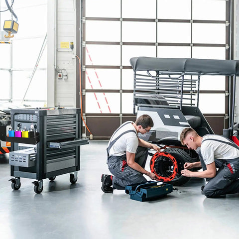 Two mechanics working on vehicle in garage with tool cart and 8 Pack Magnetic Spray Can Holders Wall Mounted Set For Garage