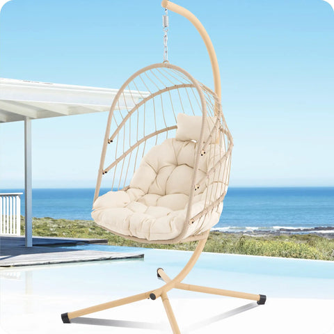 Swing Egg Chair With Stand for Indoor Outdoor Use, beige wicker rattan with UV resistant cushions by the seaside
