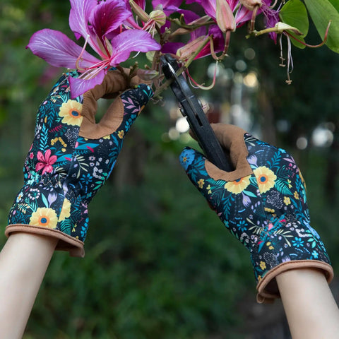 Person wearing Women's Gardening Gloves With Thorn Proof Puncture Resistant Leather, holding pruners, trimming flowers.