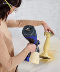Woman using Quick Finish HVLP Paint Sprayer for Crafting and Furniture on a small yellow candlestick, applying smooth even coat.