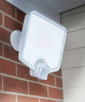 Hyper Bright LED Motion Activated Security Flood Light in white, mounted on brick wall, for backyards and perimeters