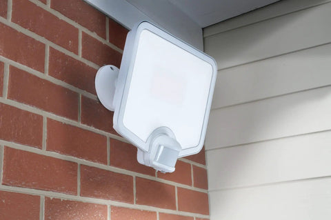 Hyper Bright LED Motion Activated Security Flood Light in white, mounted on brick wall, for backyards and perimeters