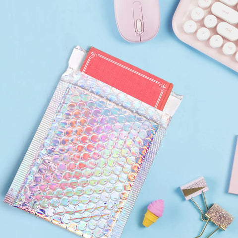 Dope Metallic Bubble Mailers Set, 50 Self Seal Padded Envelopes, Waterproof Holographic Shipping Envelopes on a desk