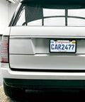 Rear view of vehicle with 2-Pack Matte Black License Plate Frames, Rust-Proof Aluminum 12.25 x 6.25 Inch, Narrow Border Keeps State Labels Visible.