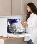 No Sweat Countertop Portable Dishwasher featuring faucet hookup and self prime pump with dishes inside.