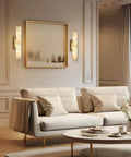 Brushed Brass And Natural Alabaster Wall Sconces Set Of Two casts a glow beside a cozy sofa in an elegant living room.
