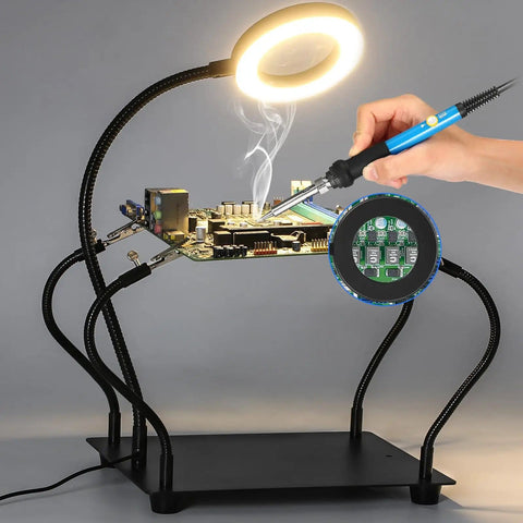 Helping Hands Soldering Station With 3X Magnifying Glass And Light in use, showcasing PCB work with flexible arms and magnifier.