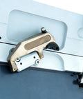 Side view of a brass-colored clamp bar installed on the edge of a sheet metal brake.