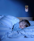 Child sleeping in bedroom with Plug-In Carbon Monoxide Detector With Digital LED Display on wall, real-time CO monitoring.