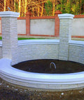 Granite Look Dope Texturing Stamp Mat for Concrete and Cement creating a stone-textured wall and pillars in a garden setting.