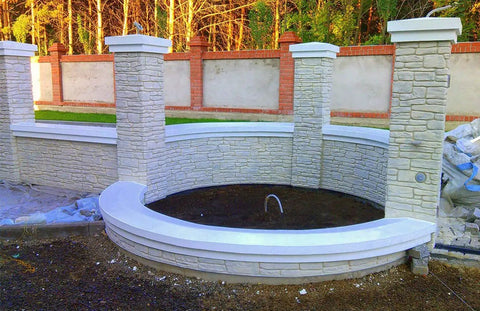 Granite Look Dope Texturing Stamp Mat for Concrete and Cement creating a stone-textured wall and pillars in a garden setting.