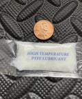 Small packet labeled 'High Temperature PTFE Lubricant' next to a coin on textured surface.