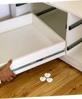 Image showing Eight Piece Stainless Steel Self Adhesive Caster Wheels for furniture relocation with a drawer being installed.