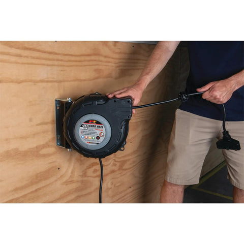Person adjusting 40 Foot 12 Gauge Retractable Power Cord Reel With Auto Rewind Spring Loaded for garage use