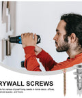 Person using a drill to insert Heavy Duty Drywall Anchor Kit With Screws, 20 Sets, Self Drilling Zinc Alloy And Iron on wall