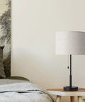 Dual USB Table Lamp Set Of 2 With Built-In 3-Prong Outlet on a nightstand in a modern bedroom, with fabric shade and USB charging base.