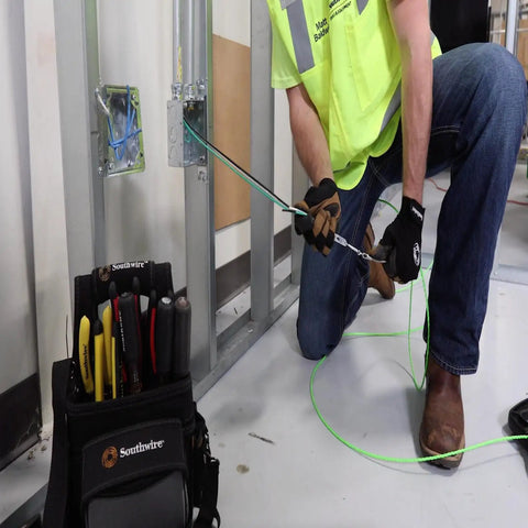 Electrician installing heavy duty building wire stranded copper 12 gauge one conductor 20 amp 600 volt in commercial site