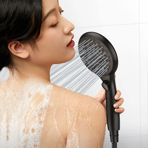 Woman using Shower Head With 7 Settings Handheld With On Off Pause Switch in oil rubbed bronze, enjoying high-pressure water flow.