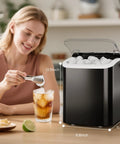 No Sweat Countertop Ice Maker With Carry Handle Whips Up 26 Pounds Of Bullet Ice In 24 Hours Via A Rapid 6 Minute Cycle Plus Auto Clean Tech For Home Kitchen Rv Camping Matte Black with a user serving ice.