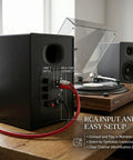 Back panel of 80W Peak Bluetooth 5.3 Bookshelf Speakers with RCA cable connected to turntable on wooden desk setup