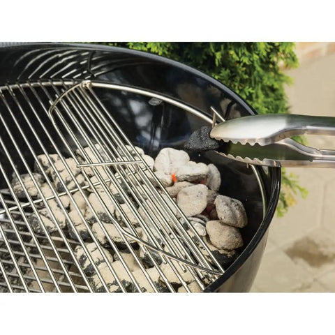 Close-up of Original Kettle Premium Charcoal Grill 22 Inch Black Outdoor BBQ Grill with charcoal and hinged cooking grate.