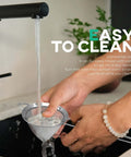3.3 Inch Fine Mesh Strainer 304 Stainless Steel Cocktail Sieve being washed under a tap, showing ease of cleaning in kitchen environment.