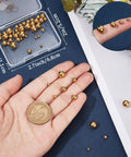 Golden 304 Stainless Steel Screw Ball Earring Backs Set, 50 Pieces In Five Sizes, shown in hand with coin for scale.