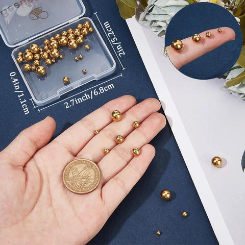 Golden 304 Stainless Steel Screw Ball Earring Backs Set, 50 Pieces In Five Sizes, shown in hand with coin for scale.