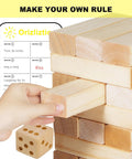 Giant Wooden Tumbling Tower 5.3 Feet Tall With 60 Premium Pieces Total Blast Outdoor Stacking Game with a hand moving a block.