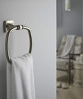 Grand Towel Ring In Vibrant Brushed Nickel, Transitional Style Bath Accessory displayed with towel against gray wall