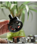 Slick Adjustable Coffee Distribution Tool And Rotatable Espresso Tamper Set for Badass Baristas, in hand over coffee grounds.