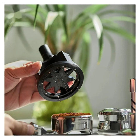 Slick Adjustable Coffee Distribution Tool And Rotatable Espresso Tamper Set for Badass Baristas, in hand over coffee grounds.