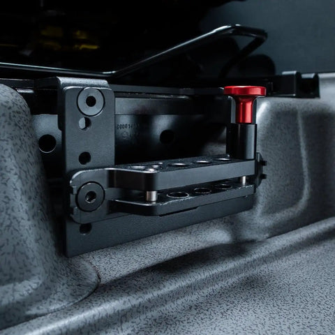 Slick Under Seat Fire Extinguisher Bracket For Ineos Grenadier Truck With One Hand Quick Release Aluminum Mount Kit and Heavy Duty Secure Ratchet Straps close-up view of mounting plate and red release knob.