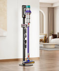 Boss Grade Steel Vacuum Stand For Cordless Vacuums in a living room, holding a Dyson V-series with accessories, black finish.