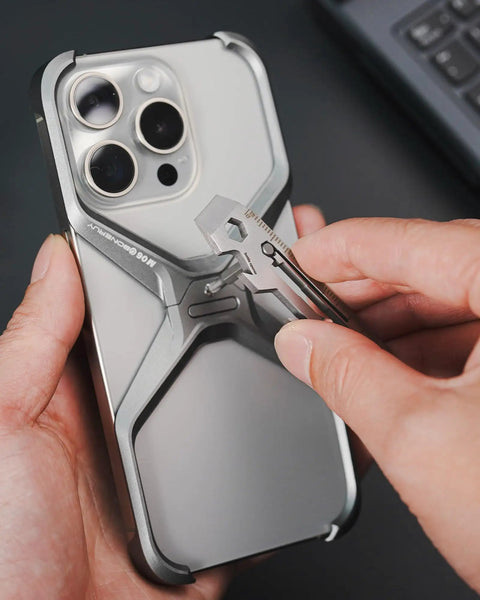 Person using KR03 EDC Pry Bar Multitool with Flathead and Phillips Driver, Bottle Opener on smartphone case, showcasing its functionality.