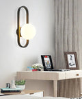 Fresh Modern Glass Wall Sconce Lighting For Bedroom And Living Room Indoors Or Outdoors Creative Nordic Style Reading Lamp With Bright LED Bulbs, mounted on a wall, with a round glass shade.