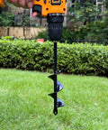 Auger Drill Bit Set Of 4 For Planting attached to orange drill over grassy lawn, showcasing black spiral earth bit for rapid planting.