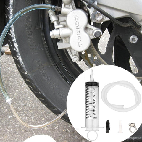 All In One Brake Bleed Kit For Hydraulic Disc Clutches And Car Brakes With 100ml Syringe, hoses, check valve, and tools next to brake system