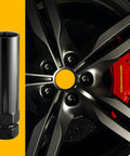 Hella Tough 7 Spline Lug Nut Key And Socket Wrench for Fuel Wheels and Rims M14 Thread next to a black alloy wheel.